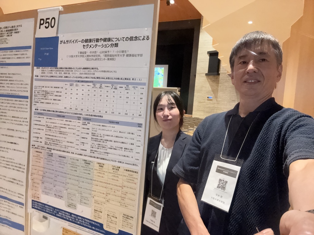 がんサバイバーのセグメント分類についてのポスター発表を行いました。平井先生と学生の2ショットです。